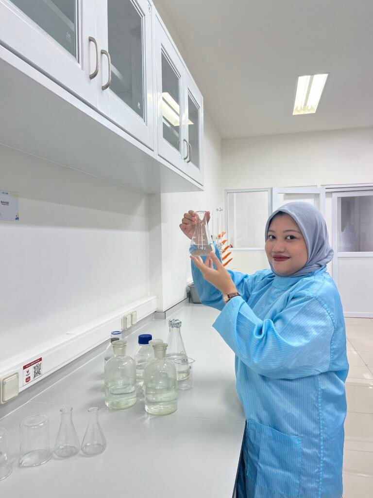 Analis labortaorium sedang membuat larutan menggunakan pipet dan erlenmeyer